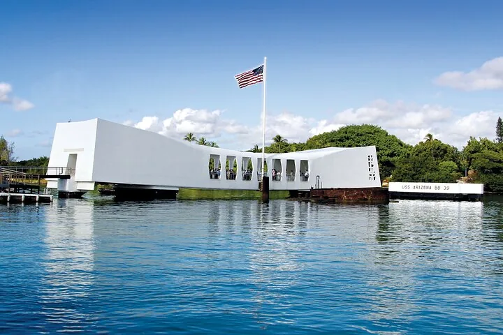 De witte structuur van het USS Arizona Memorial drijvend op het water